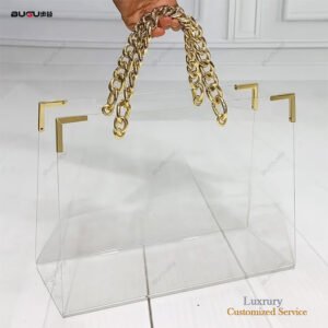Clear acrylic flower bag with gold chain handles and metal corner accents for luxury floral packaging