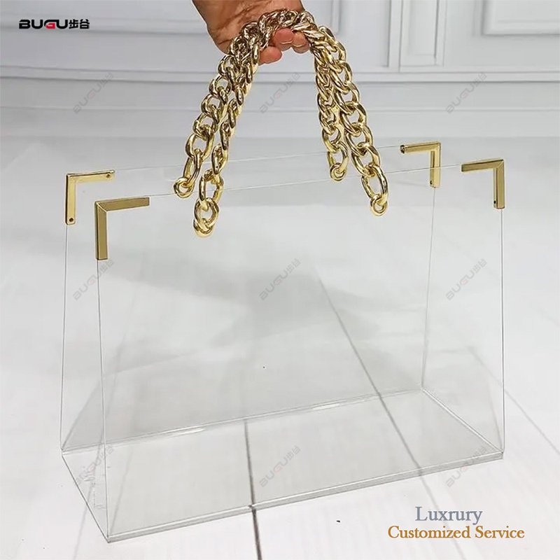 Clear acrylic flower bag with gold chain handles and metal corner accents for luxury floral packaging